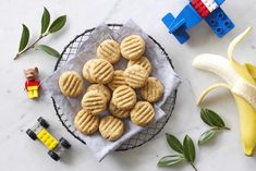 some cookies are on a plate next to legos and bananas