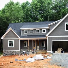 a house being built in the middle of a wooded area with lots of construction materials