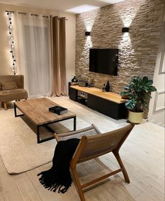 a living room filled with furniture and a flat screen tv mounted on a wall above a wooden coffee table