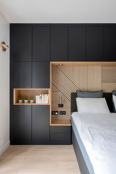 a large bed sitting in a bedroom next to a wall mounted book shelf and night stand