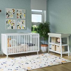 a baby's room with blue walls and white furniture