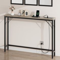 a console table with two mirrors above it and an outlet plugged into the wall