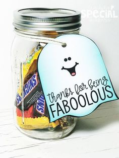 a jar filled with lots of candy on top of a white table next to a sign that says thanks for being fabulous