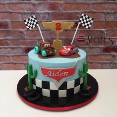 a birthday cake with cars and flags on top