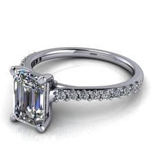 an emerald cut diamond ring with pave set shoulders