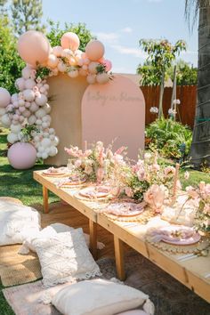 a table set up for a baby's first birthday party with balloons and flowers