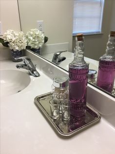 there are bottles and glasses on the bathroom counter