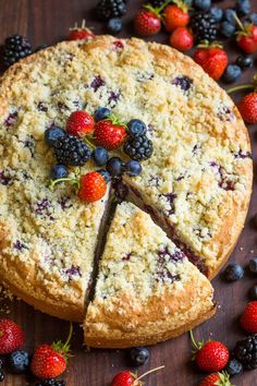 a cake with berries and blueberries cut into slices