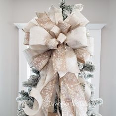 a large bow on top of a christmas tree