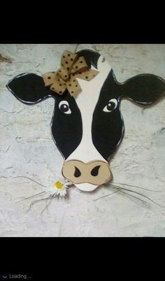 a cow with a bow on its head is shown in black and white, as well as a daisy