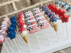 an ice cream cone with red, white and blue icing on it is lined up in rows