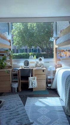 a bedroom with two bunk beds and a desk in front of a window that looks out onto the street