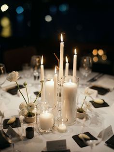 a table topped with lots of white candles