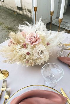 a white table topped with pink and gold place settings