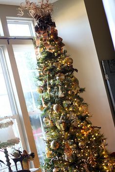 a decorated christmas tree in front of a window