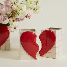 two heart shaped vases sitting next to each other