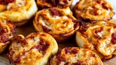 several mini pizzas sitting on top of a wooden tray