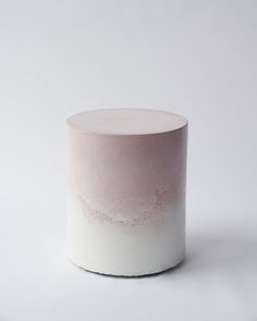 a white and pink vase sitting on top of a table