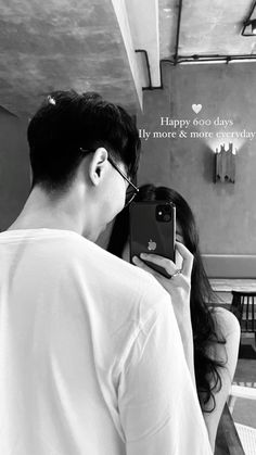 a man and woman taking a selfie in front of a mirror with the words happy valentine's day on it