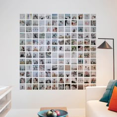 a living room filled with furniture and a wall covered in pictures on the wall next to a coffee table