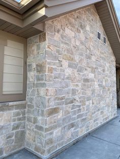 a stone building with a brown door and window on the side of it's wall