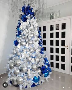 a white and blue christmas tree with silver ornaments