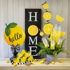 a table topped with lemons and vases next to a sign that says hello home