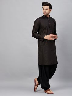 VM By VASTRAMAY Men's Black Kurta And Black Patiala Set Look sharp and sophisticated in this classic black kurta pajama set from VM by Vastramay. This set is perfect for any occasion, from a casual day out to a festive event. Key Features: Black, solid color kurta and patiala Kurta: Straight knee length, mandarin collar, long sleeves, button placket, straight hem, side slits Patiala: Solid black, elasticated waistband Made from comfortable cotton (or cotton blend) fabric Specifications: Top Shap Black Solid Color, Black Kurta, Kurta Pajama, Lehenga Designs, Black Solid, Mandarin Collar, Button Placket, Solid Black, Classic Black