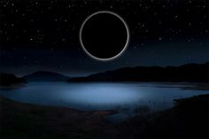 an eclipse is seen in the night sky over a body of water