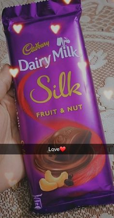 a hand holding a bag of dairy milk silk fruit and nut