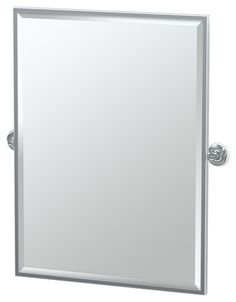 a bathroom mirror that is on top of a white wall mounted cabinet with two handles