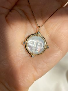 A dreamy 15mm hand-carved Mother of Pearl Moon encircled in gold, set with (4) White Diamonds, set on a solid 14k yellow gold 0.8mm box chain. (Approx. 5.7g.) Inspired in essence by the Impressionist French composer Claude Debussy, Clair de Lune translates to pale blue light or moonlight, and embodies the Divine Feminine energy of the moon, wholly encapsulating the deep sense of serenity found through inner self-awareness, and the strength kept within the gentleness of the heart. Aligns with int Elegant Sun And Moon Medallion Jewelry, Elegant Sun And Moon Design Medallion Jewelry, Fine Jewelry Moon Phase Round Pendant, Spiritual Yellow Gold Moon Phase Jewelry, Luxury Yellow Gold Sun And Moon Jewelry, Spiritual Yellow Gold Jewelry With Moon Phase, Spiritual Yellow Gold Jewelry With Sun And Moon Design, Luxury Yellow Gold Jewelry With Sun And Moon Design, Yellow Gold Moon Phase Jewelry Round Shape