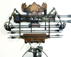 a wall mounted clock with various types of hunting equipment on it's face and hands