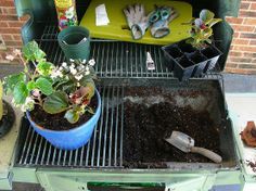 a grill with potted plants and gardening utensils