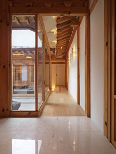 an empty hallway with wooden walls and windows