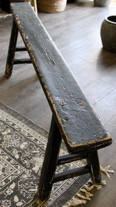 an old wooden bench sitting on top of a rug