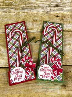 two christmas cards with candy canes on them sitting next to each other in front of a wooden background