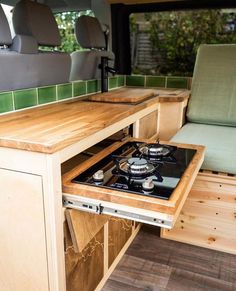 a stove top oven sitting inside of a camper