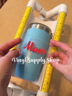 two hands holding a blue cup with measuring tape around it and the words mom vinyl supply shop