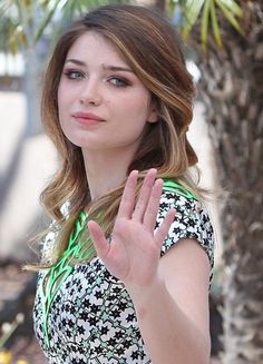 a beautiful young lady holding her hand up in the air