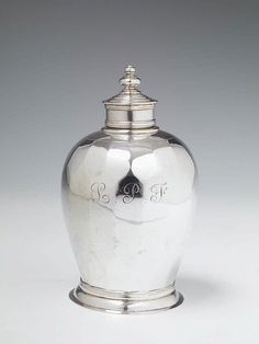 an antique silver urn with the initials b & g on it's side