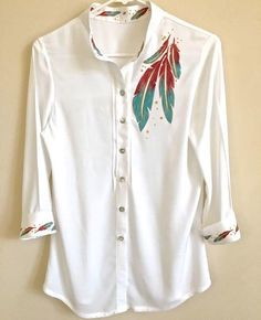 a white shirt with red and green feathers on it