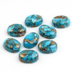 six turquoise and gold colored stones on a white background