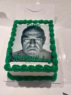 a birthday cake with an image of a man's face on the frosting