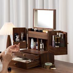 a woman is pointing at the contents in her vanity