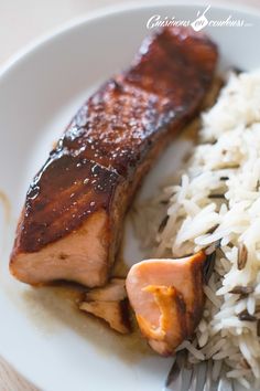 a white plate topped with meat and rice