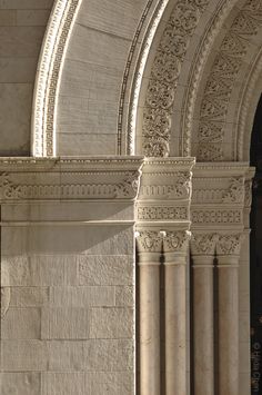 an arched stone building with a clock on the wall