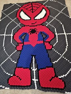 a crocheted spiderman rug is on the floor in front of a carpet