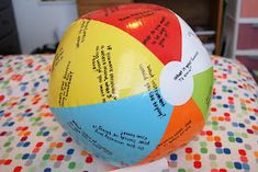 a colorful ball sitting on top of a bed covered in lots of words and phrases