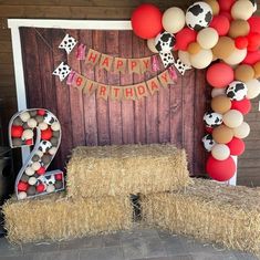 a birthday party with hay bales, balloons and farm animals on the front wall